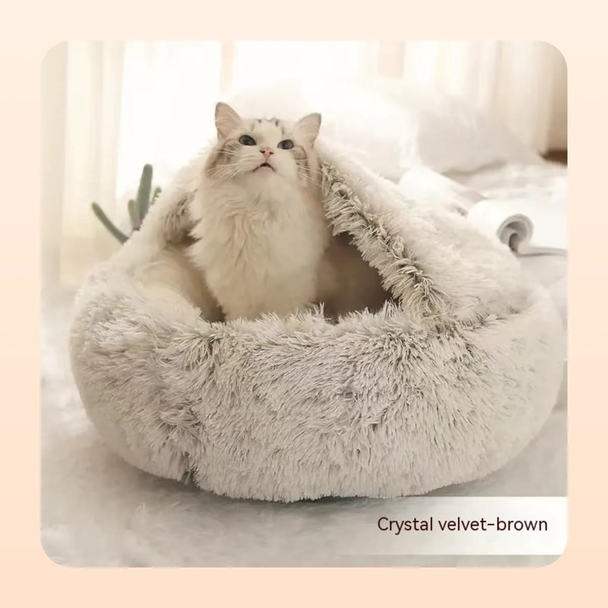 Cat sitting up in the Kindral crystal velvet burrow bed in brown