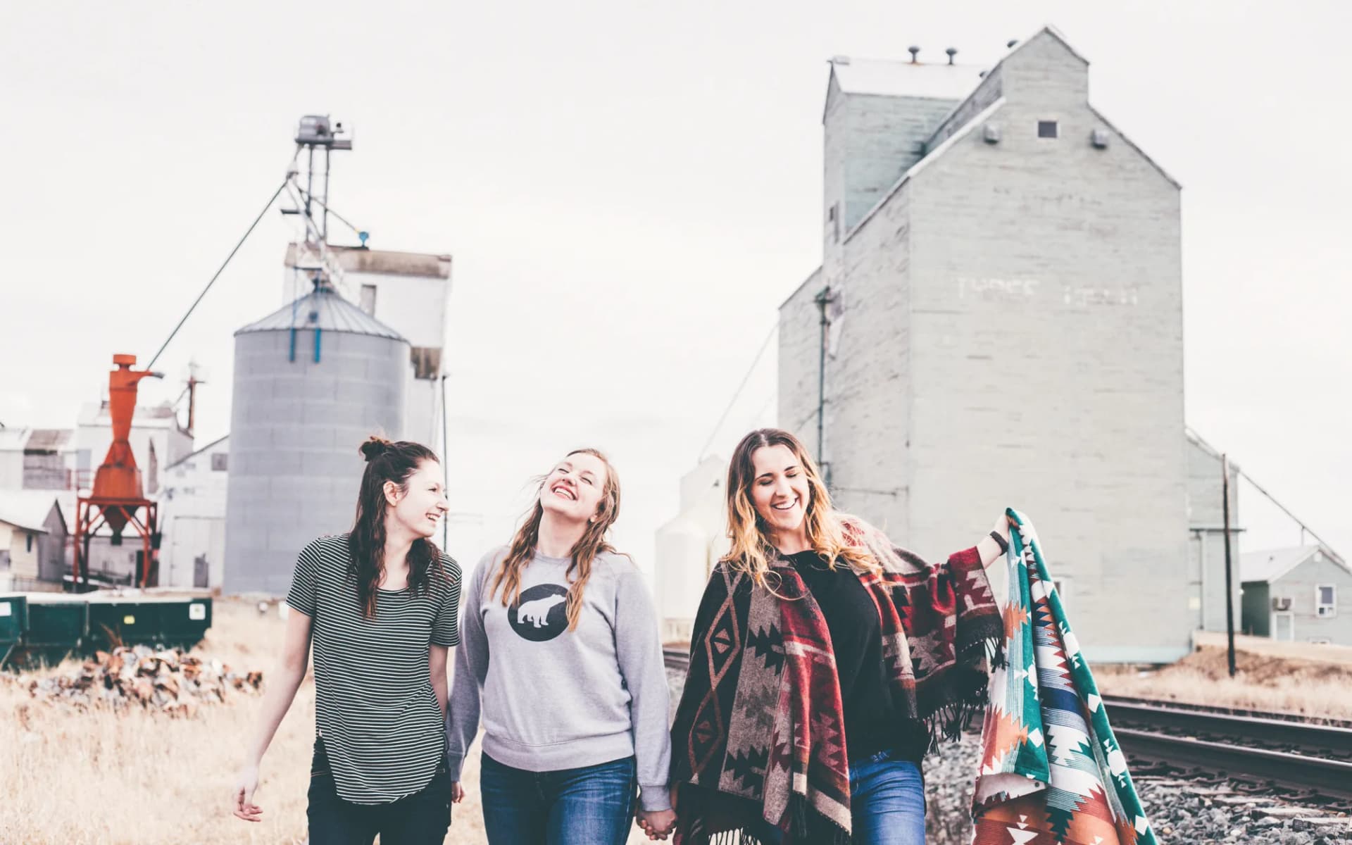 Three friends walking side by side, laughing together